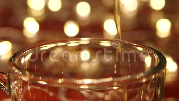特写镜头将热红茶倒入玻璃透明杯视频的预览图