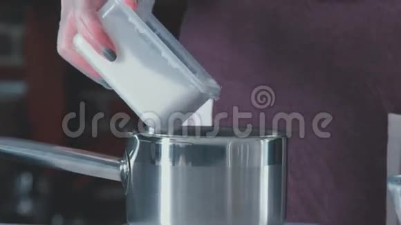 女性的手把面粉倒入金属锅中面粉和鸡蛋混合视频的预览图