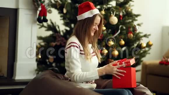 美丽的微笑女孩打开圣诞礼物视频的预览图