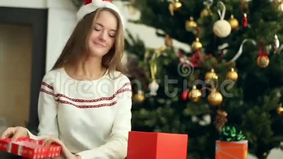漂亮的微笑女孩打开圣诞礼物视频的预览图