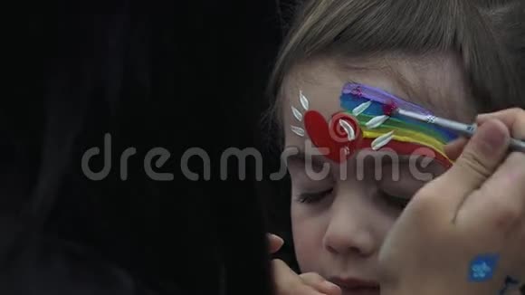 小女孩把她的脸画成彩虹脸画艺术家视频的预览图