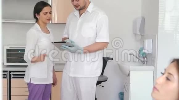 牙医与年轻女助手讨论他的病人诊断视频的预览图