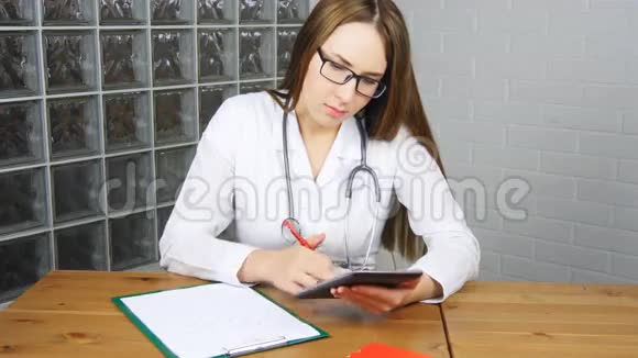 女医生在办公室用平板电脑视频的预览图