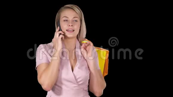 带着购物袋的年轻女子在用手机说话阿尔法频道视频的预览图