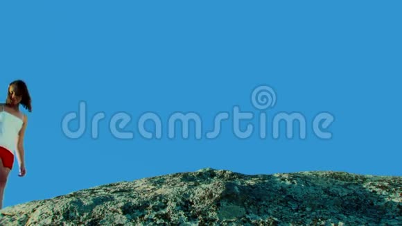 在蓝天的映衬下两个女孩在岩石上漫步视频的预览图