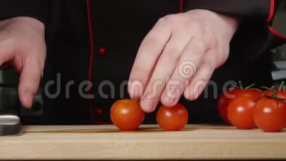 厨师在厨房的砧板上切樱桃西红柿视频的预览图