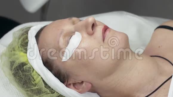 成年妇女躺在美容院眼睛下面放着棉垫永久染色视频的预览图