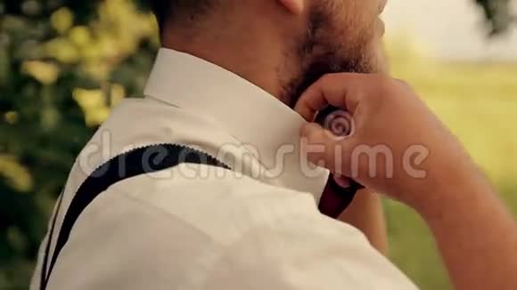 一个穿西装留胡子的人把他的领带弄直了视频的预览图
