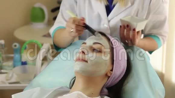 年轻的女人带着面膜在水疗中心水疗沙龙的女人视频的预览图