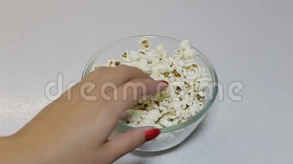 女人的手拿着盘子里的爆米花视频的预览图