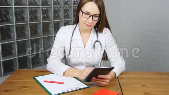 女医生在办公室用平板电脑视频的预览图