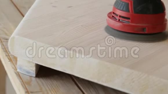 木工在车间特写中用电动砂光机打磨木台阶视频的预览图