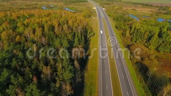 林景观中的公路道路在柏油路上行驶的汽车的鸟瞰图视频的预览图
