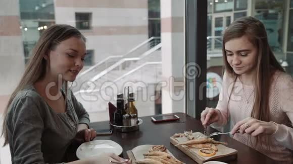 朋友两个年轻的女人在咖啡馆见面商务午餐在面糊里说和吃鱼视频的预览图