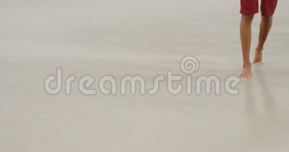 在阳光明媚的4k天气里一个人赤脚在海滩上行走视频的预览图