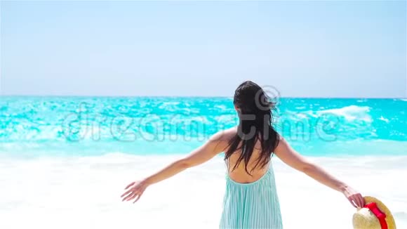 美丽的女人微笑着在白色海滩上的暑假快乐快乐的女孩穿着夏天的衣服散步视频的预览图