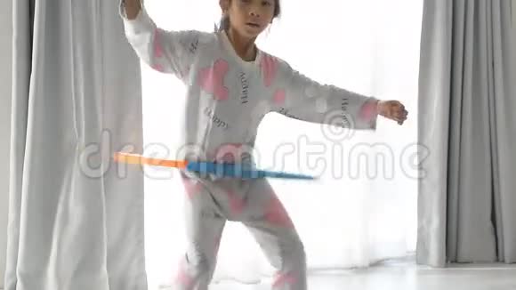 在窗户附近玩呼啦圈的亚洲女孩视频的预览图