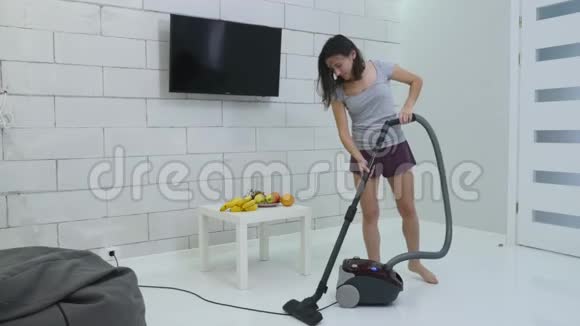 一个年轻女孩正在用吸尘器打扫房子视频的预览图