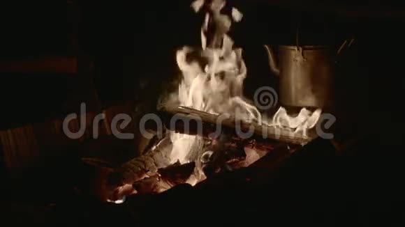 老式水壶在慢动作的火焰中燃烧木头视频的预览图