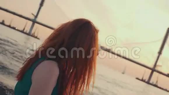 穿着绿松石衣服坐在摩托艇上的快乐女孩享受美丽的日落视频的预览图