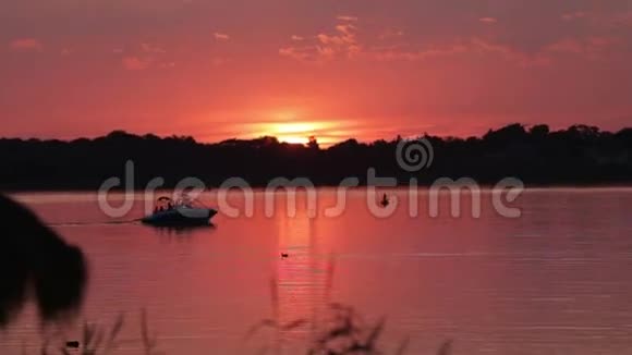 日落时摩托艇在湖上行驶视频的预览图