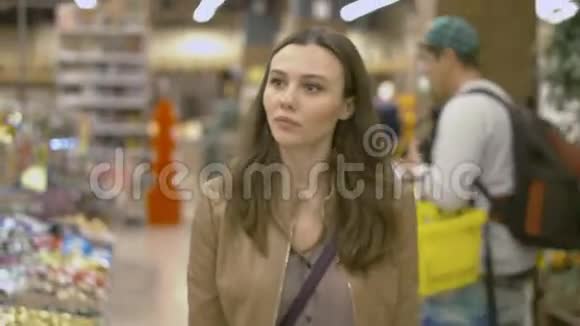 可爱的年轻女子在超市里散步视频的预览图