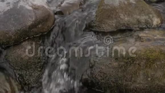 冬季的小山溪在石头和巨石上翻滚的水流视频的预览图