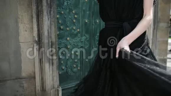 苗条的女孩穿着黑色壮观的裙子在镜头前摆姿势旋转视频的预览图