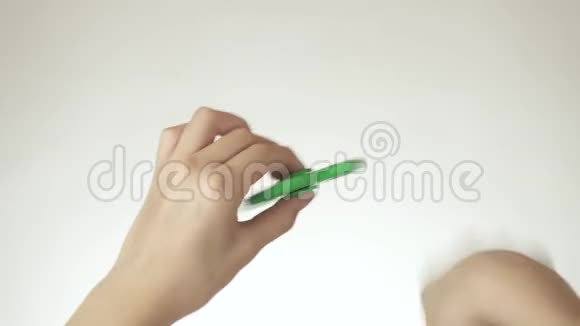 一个十几岁的女孩的手在白色背景的股票视频上旋转一个绿色的烦躁旋转者视频的预览图