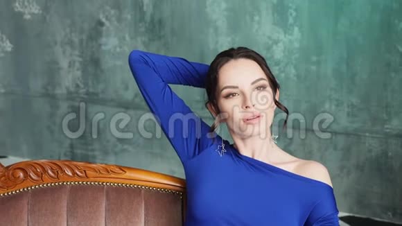 穿蓝色长裙的女孩躺在旧沙发上视频的预览图