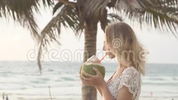 快乐的海滩比基尼女郎放松地喝新鲜的椰子水躺在乐趣的加勒比海度假日光浴中视频的预览图