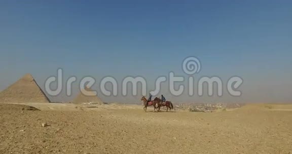 在吉萨金字塔前和当地人骑马的女人视频的预览图