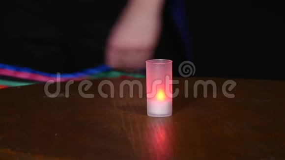 魔术师在黑暗的背景上用围巾和蜡烛表演魔术视频的预览图