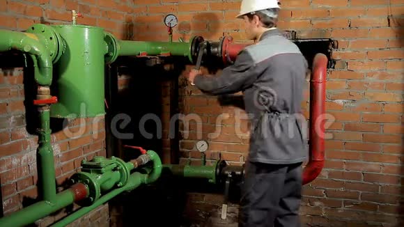 一名穿工作服的工人打开水阀这个人包括锅炉房的暖气视频的预览图