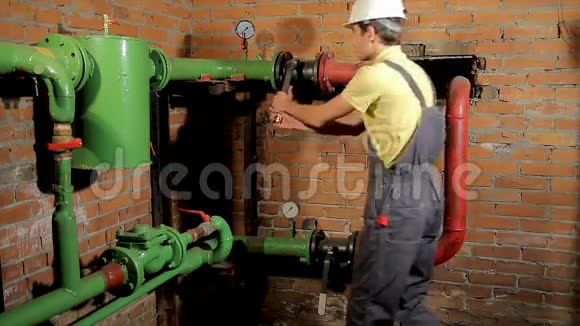 一名穿工作服的工人打开水阀这个人包括锅炉房的暖气视频的预览图