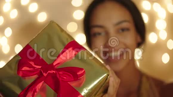 美丽的黑人妇女手里拿着大礼盒微笑着视频的预览图