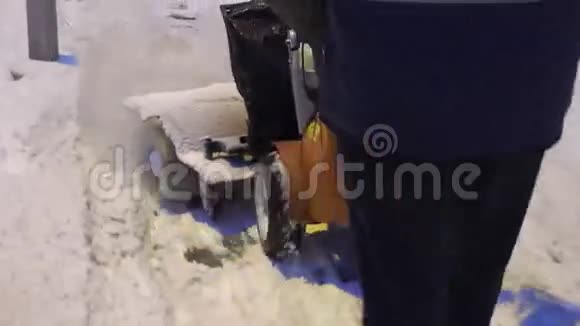冬天下雪后人们在人行道上用吹雪机工作4K视频的预览图
