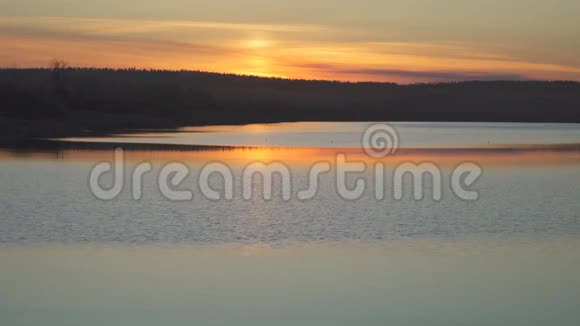 一个夏天橙色的日落在湖面上反射视频的预览图