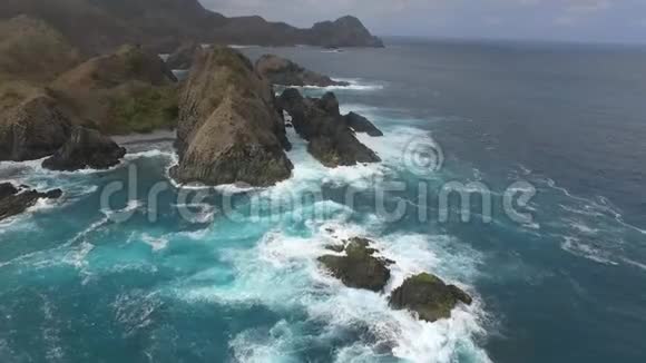 沙滩上的蓝色海浪大浪冲击岩石海岸视频的预览图