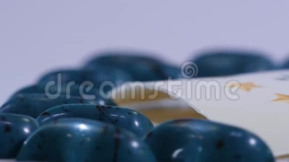蓝色糖果周围的团队标志关闭糖果放在桌子上蓝色和黑色棒棒糖慢动作视频的预览图