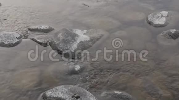 冬季溪流中的小山河在石头和巨石上视频的预览图