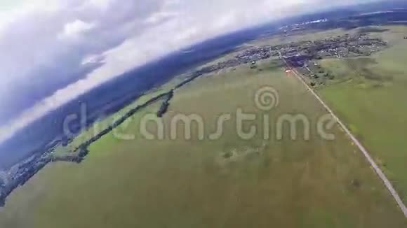 跳伞运动员在绿色的田野上跳伞高空晴天视频的预览图