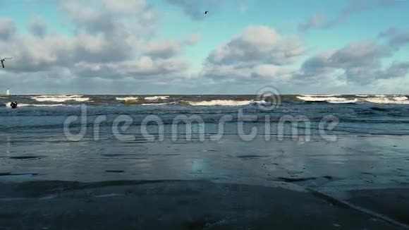 暴风雨过后的冬季沙滩用泡沫卷成大浪视频的预览图