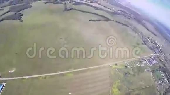 专业跳伞运动员乘降落伞飞越绿茵场等景观视频的预览图