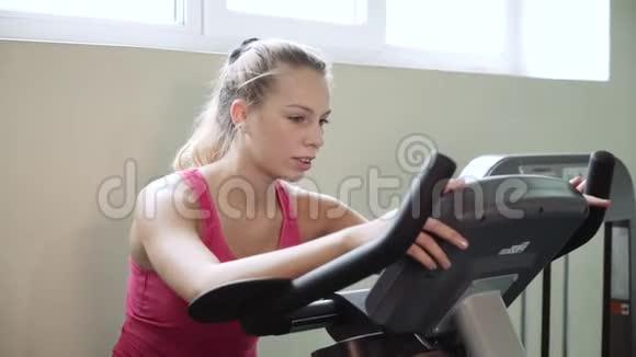 漂亮的女孩正在骑健身车锻炼理念热爱运动参加健身房适当的营养苗条的身材视频的预览图
