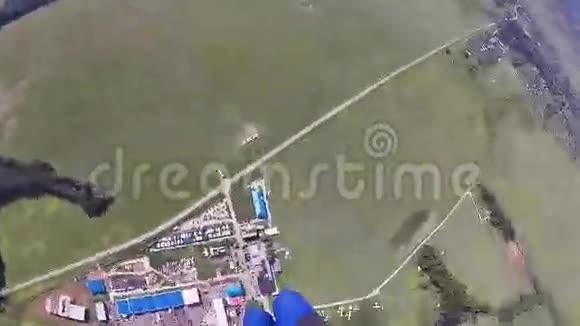 跳伞者在绿色的田野森林上空跳伞高空晴天视频的预览图