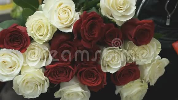 一束白玫瑰和红玫瑰放在膝盖上视频的预览图