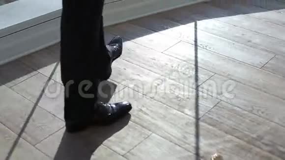 黑色专利皮革男鞋在窗户附近复古的内饰那个穿裤子穿黑鞋的人在窗边视频的预览图