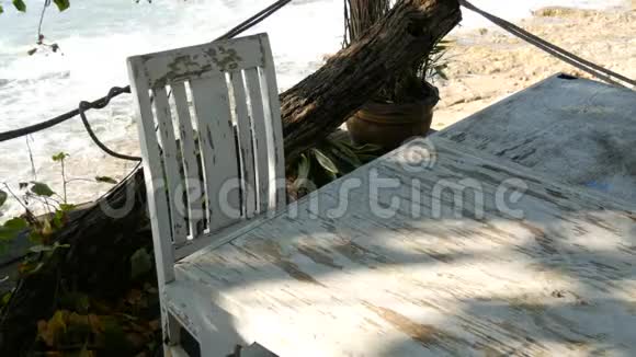荒凉的咖啡馆海边有白色的木椅海边的咖啡桌视频的预览图