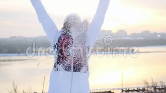 快乐的年轻活跃的女人在日落的城市背景下在冬天的田野里玩得很开心在缓慢的运动中扔雪1920x1080视频的预览图